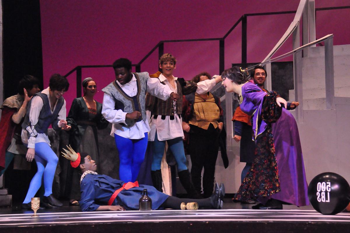 A group of performing arts students in medieval-themed clothing performing on stage